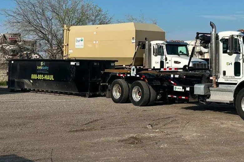 EnviroHauling roll-off container, a trash compactor and trucks in the yard