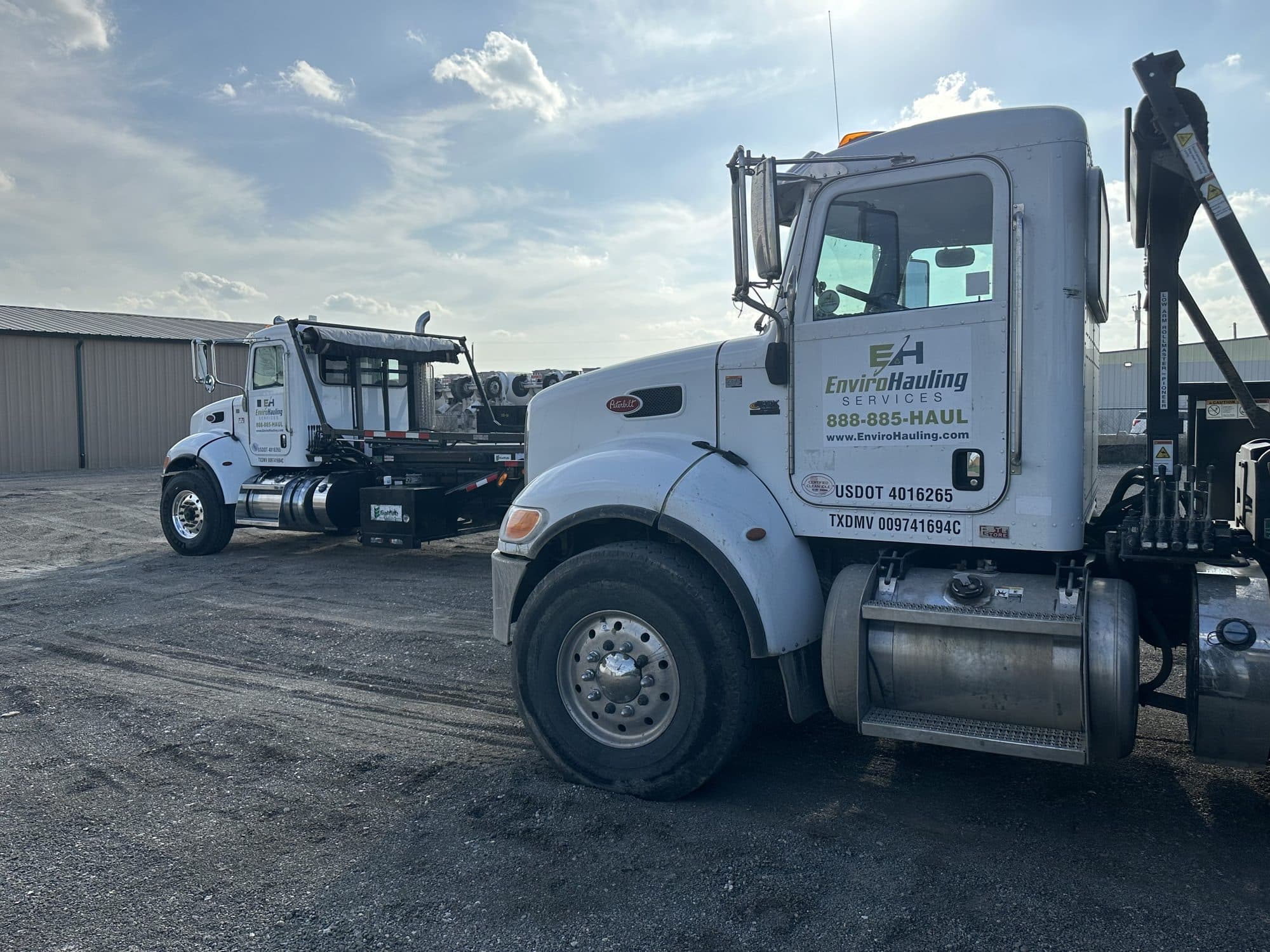 EnviroHauling roll-off truck with the logo and 888-885-HAUL on the cab door