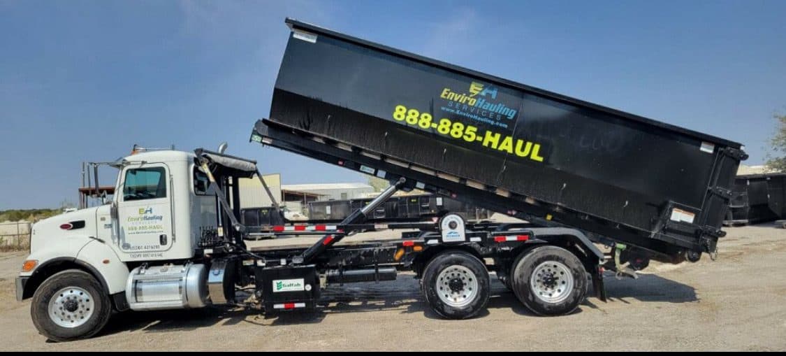 EnviroHauling truck tipping a roll-off container into place